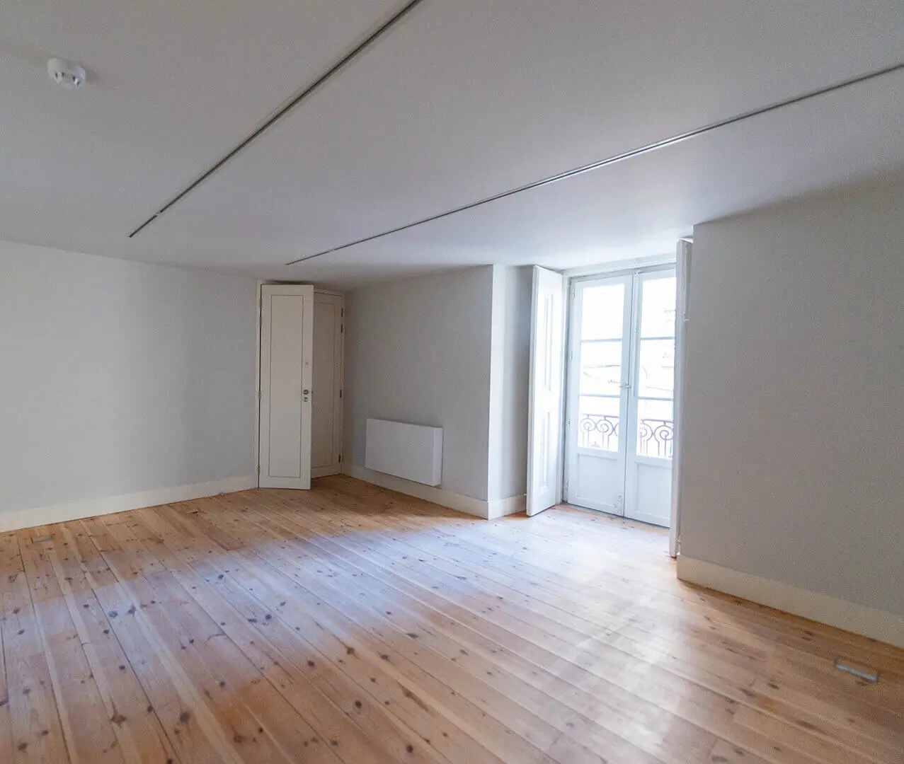 Empty room with a wooden floor and white walls, before installation