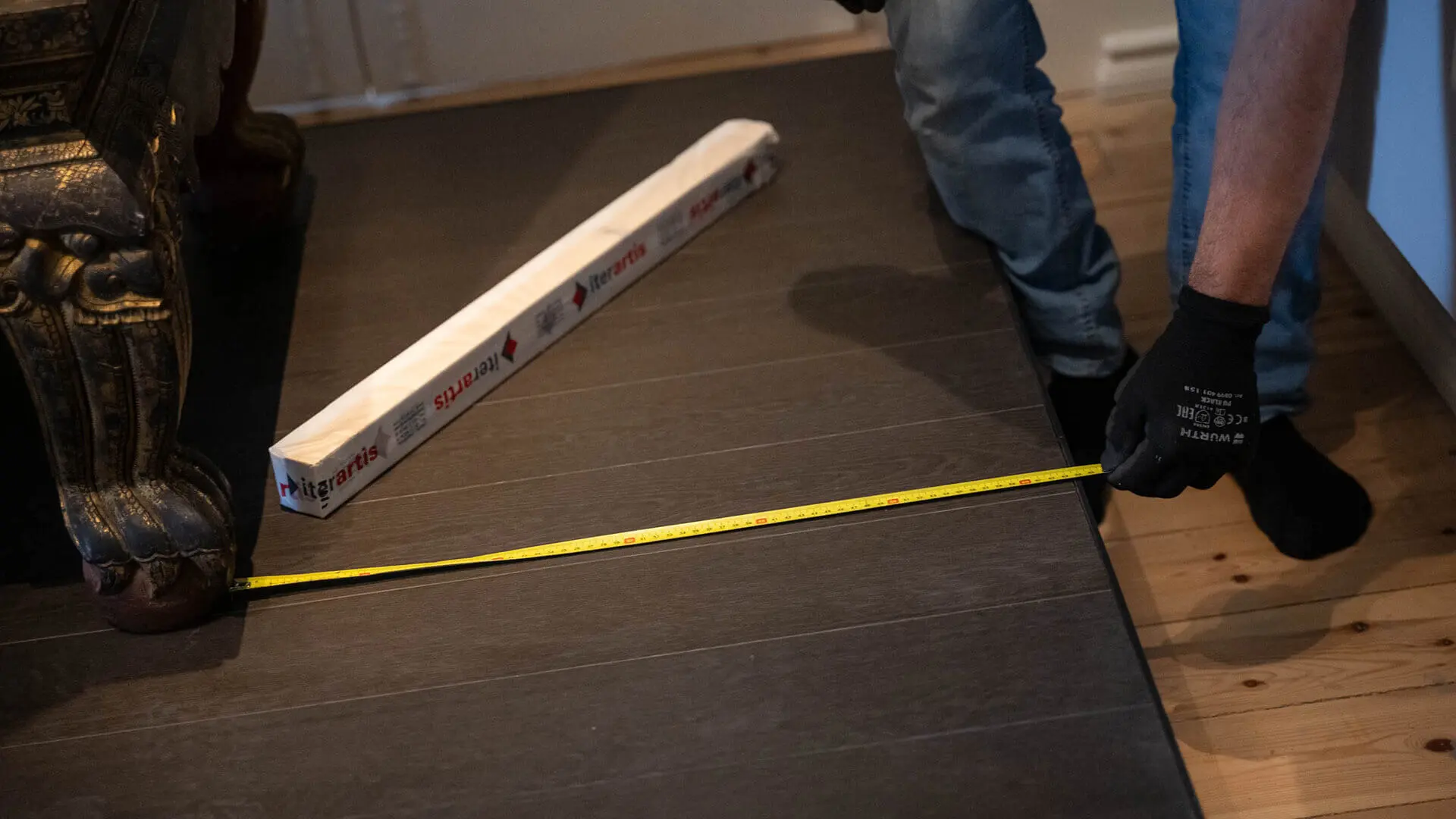 Technician measuring the space for an object on a dark platform with a tape measure