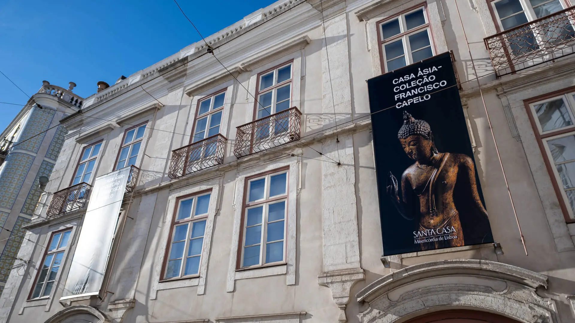 Exterior façade of the museum, with an exhibition banner showing a Buddha statue