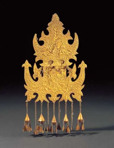 Ornamento dourado recortado, com pingentes em forma de sino, sobre fundo escuro